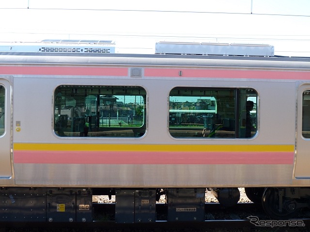 E129系の側面。車内は運転台のある側がロングシートで、運転台のない側はボックスシートが設けられていた。帯の色は新潟を連想させる黄金色(稲穂)と、薄いピンクのトキ色を用いている。