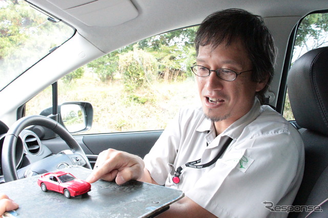 マツダ 操安性能開発部の虫谷泰典氏。RX-7のミニカーで車体の浮き沈みを解説する