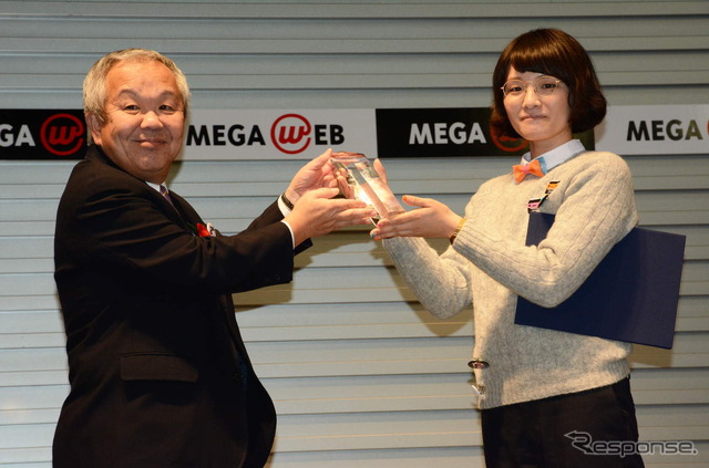 花本博志JAFCA理事長(左)からトロフィーを受け取る江口奈津美デザイナー