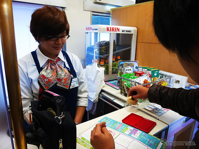 車内の販売コーナーでスタンプラリーの判を押す乗客(鉄道むすめスカイツリートレイン出発式、2015年1月17日、東武鉄道大宮駅)