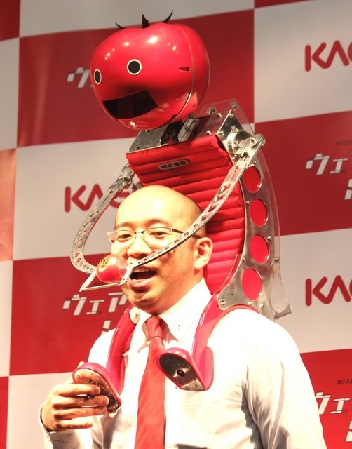 ウェアラブルトマトを使って、口元にトマトを運んでいるところ