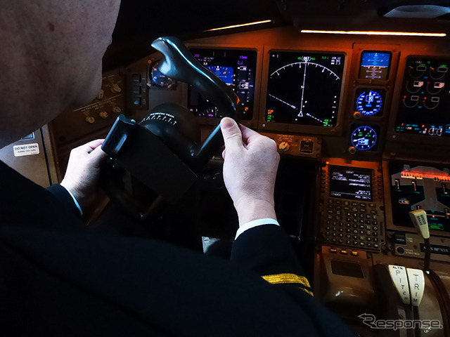 操縦ホイールをまわす船越機長。「手動で操縦ホイールやラダーペダルを操作し、まっすぐに飛ぶ状態にしたあとにトリムスイッチを操作して手を放してもまっすぐに飛ぶように調整します」(日本航空) 羽田空港内JALメインテナンスセンター1(M1ハンガー)