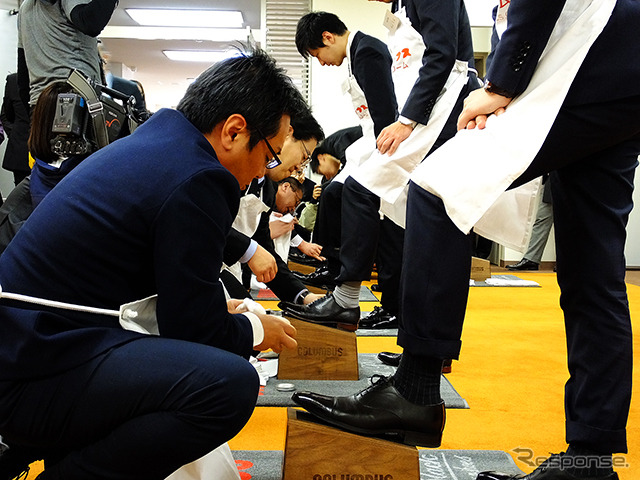 コロンブスの新人と社員が握手を交わし、先輩が手本を見せるかたちで新人の靴をみがき上げると、こんどは社員のアドバイスを聞きながら、新人たちが先輩の靴をみがいた(4月1日、コロンブス「靴みがき入社式」)