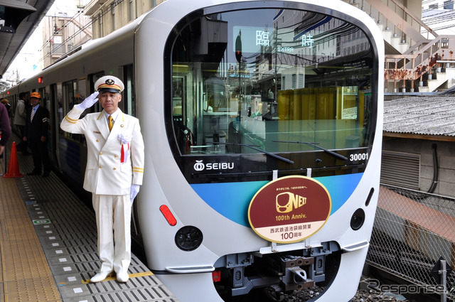 西武池袋線開業100周年記念電車と、敬礼する土屋敏行池袋駅管区長