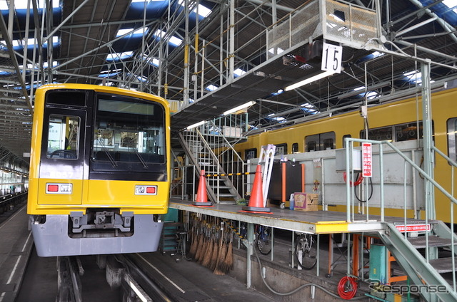 西武鉄道は4月18日から運行を開始する「黄色い6000系電車」のラッピング作業を公開した。黄色い電車の2000系(右)と並ぶラッピング車の6000系