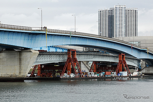 台船で晴海運河を移動する橋桁。既存の晴海通り延伸部をくぐり、目標の位置へと接近する