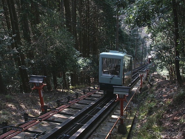 木々が生い茂る山腹を登る鞍馬山ケーブルカーの3代目車両「牛若号III」。来春の運行再開時には4代目車両が導入される。