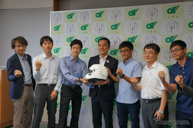 知事からの応援メッセージが書かれたヘルメットとともに記念写真