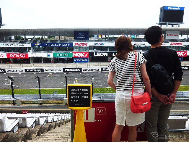 鈴鹿サーキットでブライダルフェアを開催。参加したカップルたちは、国際レーシングコースやVIP席が“挙式会場”となる場面を想像しながら見学していた(三重県鈴鹿市・鈴鹿サーキット、2015年6月14日)