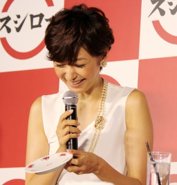 田丸麻紀が、スシロー初のオリジナルキャラクターがデザインされた寿司皿を見ているところ