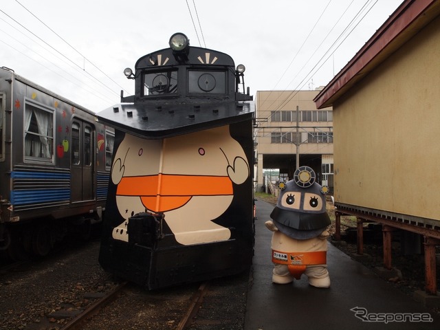 青森県の弘南鉄道でこのほど、子どもたちがラッセル車キ100形にラッピングを施すイベントが開かれた。マスコットキャラクター「ラッセル君」(右)デザインのラッピングを施したキ100形