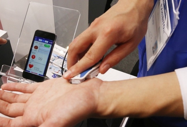 ウェアラブル近赤外分光センサを使ったバイタルセンシングのデモ。数値は接続したスマートフォンに表示されていた(撮影:防犯システム取材班)