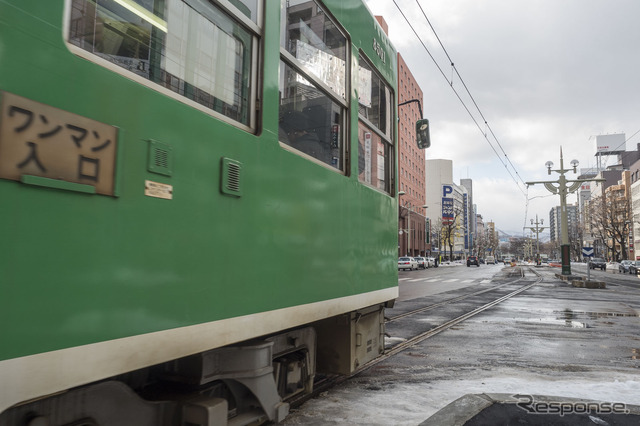 外側へ膨らみながら資生館小学校前方向の従来線へ入る外回り線の電車。