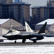 雪化粧した横田基地にF-22ラプターが次々と降りてくる。
