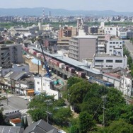 貨物列車が走り抜けて行く都島駅の工事現場。おおさか東線は貨物線を旅客化する形で整備が進められている。