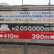 JR西日本がカープロードに設置した看板。広島～札幌間の距離と時刻表が記されている。