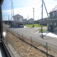 秋田港貨物支線の車窓。普段見られない旅客列車を珍しそうに眺める人がいた。