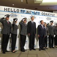 星野社長（中央右）と五十嵐秀交通サービス事業本部長（中央左）の両脇で敬礼する、新制服を着用した小田急の現役職員。新制服は2018年3月中旬に導入される。