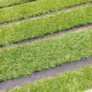 昭和造園土木のタフグリーンは、芝生に必要な土の厚さ15cmを確保した駐車場の芝生保護材（芝生駐車場）だ。写真の芝はさんぷるの人工芝。