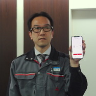 三菱電機ビルテクルサービス技術開発本部保守技術開発部の田畠宏泰さん。手にしたスマホ画面がアプリ