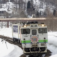 鹿ノ谷駅を出た新夕張行き列車。ヘッドマークは前後で異なるデザイン。車両も前からJR北海道色、「北海道の恵み」色、日高色と1両ずつ異なる塗色だった。2019年3月30日撮影。
