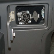 運転席の左側に用意された普通充電用コネクタ口を装備