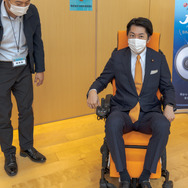 経済産業大臣政務官・佐藤啓氏も、展示コーナーで様々な電動車いすを試乗していた。