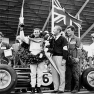 1963年イギリスGP、ジムクラークが25クライマックスで優勝。チャップマンとともに表彰台に上る