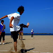 日本海へ向けて思いっきりビーチサンダルを蹴飛ばす参加者たち