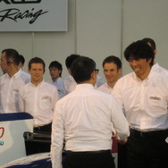 ダカールラリーで市販車部門優勝した三橋が豊田社長（背中）と握手。