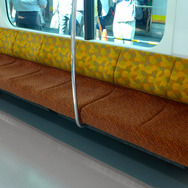 南武線用E233系の車内。座席は南武線カラーをイメージした色彩となっている