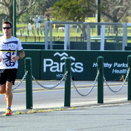 日本語Tシャツを着た地元ランナーがピット・レーンを走る。足の短い日本人ランナーに気づいた彼は、親指を立てて追い抜いていった。
