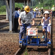 秋田内陸縦貫鉄道の子供向け車両基地公開イベントは8月に行われる。写真は軌道バイク体験の様子。