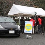 車いす参加者の早期検知の実証実験が行われた駐車場内に設置されたテント。テント手前のカメラで来場する車のナンバーを撮影していた（撮影：防犯システム取材班）