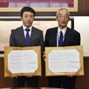 熊本県山鹿市役所で行われた契約締結調印式の様子。山鹿市長の中嶋憲正氏（右）とブリヂストン熊本工場長の原島寛氏