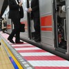ベビーカー事故を受け赤白2色の「注意喚起シート」が貼られたホーム。隙間の検知幅も従来の15mmから10mmに変更して精度を上げた。