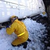 雪ベラを使って行なわれている従来の雪落とし作業。