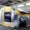 塗装ブース内で作業中の車両