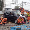 事故車はハイブリッド車なので、むやみに車体に触ると感電の恐れがある。そのため専門の救出チームが作業する。ボンネット上の隊員は専用の鋸でガラスを切っている。