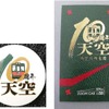 ツアー参加者に進呈される記念缶バッジ（左）と10周年記念乗車証（右）。