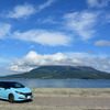 桜島をバックに記念撮影。背後の浜は海水浴場。