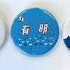 切符と同梱されるヘッドマークイメージの缶バッジ。右はひら仮名書きとなっているが、『有明』の愛称自体は準急時代の1951年11月から存在しており、特急の愛称になる前のものをイメージしたものと思われる。
