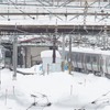 雪に埋もれるようにホームに佇む電車。2022年2月22日、函館本線小樽駅。