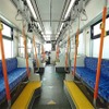 ライトグレーを基調とした6000形の車内。シートは帆船の帆や石畳、ステンドグラスといった長崎の風景をモチーフにしたブルー系。オレンジ色の握り棒を斜めに立てることで通路の空間を拡大している。照明は面発光LEDで、LED特有の眩しさを軽減。定員は62人。