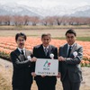 「春の四重奏」を背景に朝日町「みんなで未来！課」の発足式での記念撮影。左から、博報堂DXソリューションデザイン局の中村 信局長、笹原靖直町長、博報堂常務執行役員の名倉健司氏