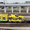 完成した電柱建替用車両。左からバケットを使って電線や電車線金具類の取付け・取外し作業を行なう「電柱用高所作業車」、電柱にあるトロリ線などを支持している金具を仮受する「装柱作業車」、クレーンでコンクリート製電柱を引き抜き、鋼管柱を建植する「電柱建植車」、鋼管柱と撤去したコンクリート製電柱を運搬する「電柱運搬車」。
