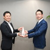 三浦選考委員長（右）からトロフィーを受け取る大矢主査