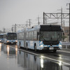 雨の中自動運転・隊列走行中の連節バス（右）、大型バス、小型バス（左）