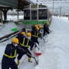 2月6日来の大雪で千歳線平和駅（札幌市厚別区）で立ち往生した721系普通列車の前で懸命に作業を行なう除雪作業員。