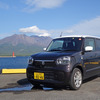 スズキ アルト HYBRID Xのフロントビュー。桜島をバックに記念撮影。